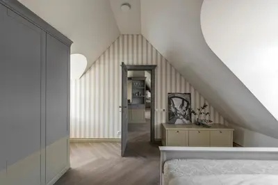 a attic room with a staircase and a bed at City Entrance Apartment in Vilnius