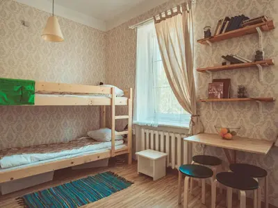 a bedroom with bunk beds and a table and chairs at Downtown Forest Hostel & Camping in Vilnius