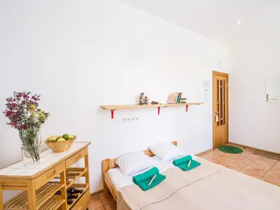 a bedroom with two beds and a wooden table at Downtown Forest Hostel & Camping in Vilnius