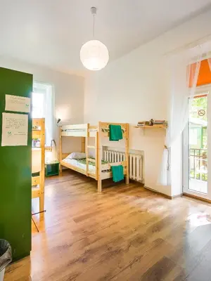 a room with three bunk beds and a wooden floor at Downtown Forest Hostel & Camping in Vilnius