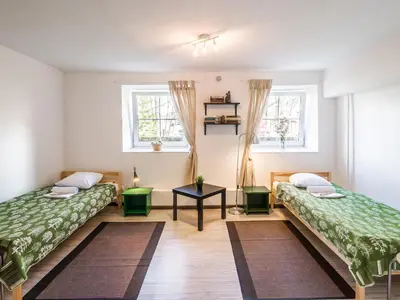 two beds in a room with two windows at Downtown Forest Hostel & Camping in Vilnius