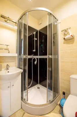 a shower in a bathroom with a sink and a toilet at Mini dvivietis Free parking in Vilnius