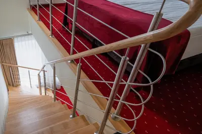 a staircase with a red bed in a room at Agneta Apartamentai in Druskininkai