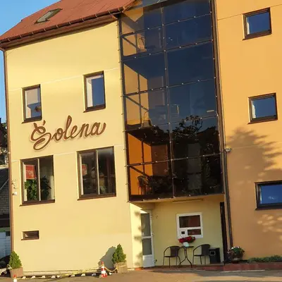 a building with a sign on the side of it at Šolena in Alytus