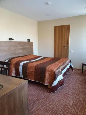 a hotel room with a bed and a door at Šolena in Alytus