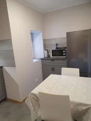 a kitchen with a table and two chairs and a microwave at Šolena in Alytus