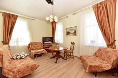 a living room with a table and chairs and a tv at Dalija in Druskininkai