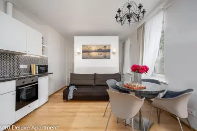 a kitchen and living room with a table and a couch at HOME Apart-Hotel Vilnius in Vilnius