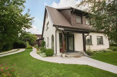 a house with a walkway leading to the front yard at Dina Apartments in Druskininkai