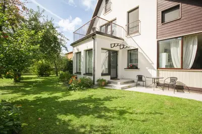 a backyard of a house with a grass yard at Dina Apartments in Druskininkai