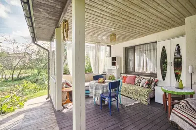 a screened in porch with a table and a couch at Dina Apartments in Druskininkai