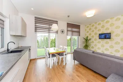 a kitchen and dining room with a table and a couch at Birutes House in Druskininkai