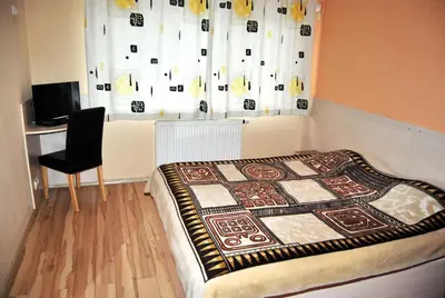 a bedroom with a bed and a chair and a window at Kambarių nuoma - Šiauliai SAURIDA in Šiauliai