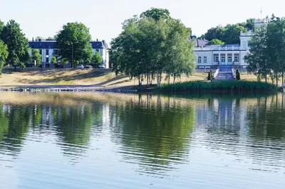 an island in the water in front of a building at Mono Ray Apartments in Druskininkai