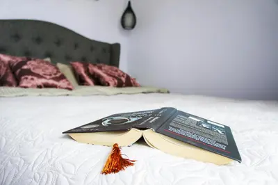 a book sitting on top of a bed at Mono Ray Apartments in Druskininkai