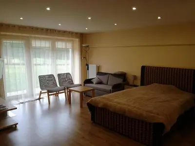 a bedroom with a bed and a couch and chairs at Apartamentai Klonio g. in Druskininkai