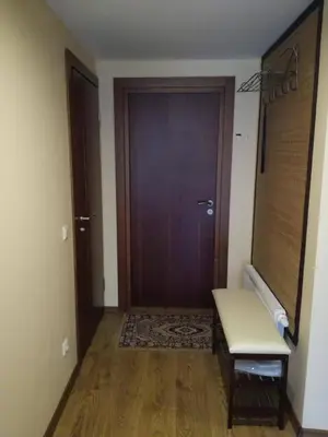a hallway with a door and a bench in front of it at Apartamentai Klonio g. in Druskininkai