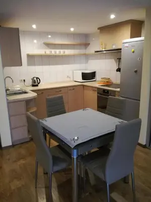 a kitchen with a table and chairs and a refrigerator at Apartamentai Klonio g. in Druskininkai