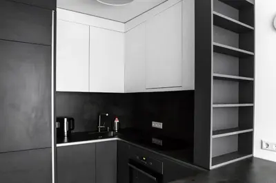 a black and white kitchen with white cabinets at Deluxe Apartments by Hostlovers in Kaunas