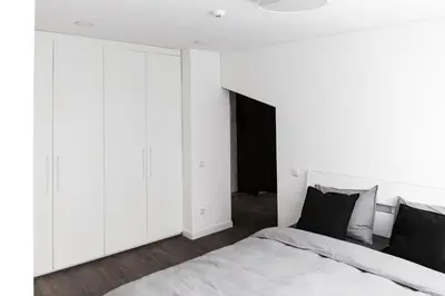 a bedroom with white cabinets and a bed at Deluxe Apartments by Hostlovers in Kaunas