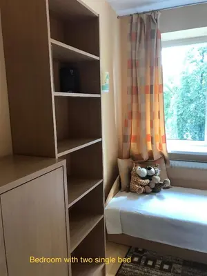 a bedroom with two single beds and a window at Roman in Druskininkai