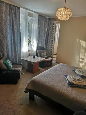 a bedroom with a bed and a chandelier at Čiurlionio 83 Druskininkai in Druskininkai
