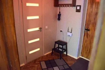 a hallway with a door and a stool in a room at Čiurlionio 83 Druskininkai in Druskininkai