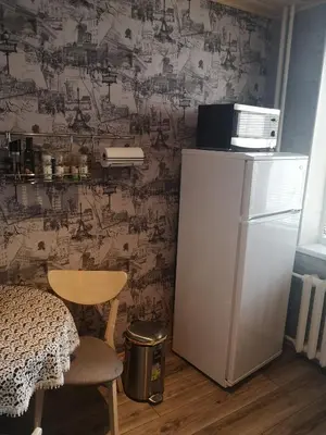 a kitchen with a refrigerator and a table and a wall at Čiurlionio 83 Druskininkai in Druskininkai