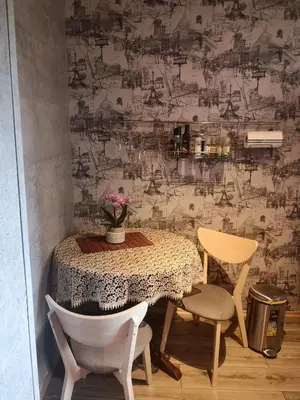 a table with two chairs and a vase of flowers at Čiurlionio 83 Druskininkai in Druskininkai