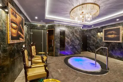 a bathroom with a tub with a chandelier at Sofijos Rezidencija in Birštonas