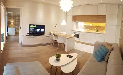 a living room and kitchen with a couch and a table at HaPPy InnSide, Free Parking, Self check-in 7x24h, AC in Vilnius