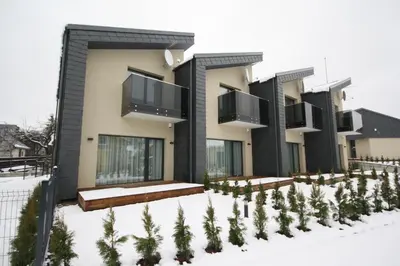 a building in the snow with trees in front of it at Nikolas Apartamentai - Birstono 7 in Druskininkai