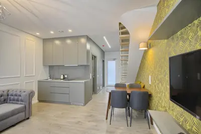 a kitchen and living room with a table and chairs at Nikolas Apartamentai - Birstono 7 in Druskininkai