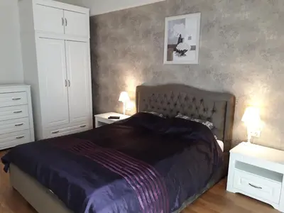 a bedroom with a large bed and two night stands at Mickeviciaus str apartment in Kaunas