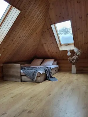 a bedroom with a bed in a wooden house at Graikinė in Kėdainiai
