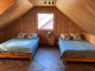 two beds in a attic room with a window at Graikinė in Kėdainiai
