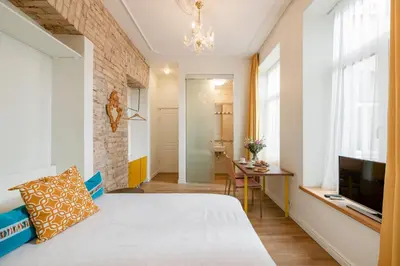 a small room with a bed and a television at Guoda Apartments in Vilnius