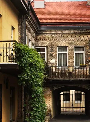 a brick building with an archway and a balcony at Guoda Apartments in Vilnius