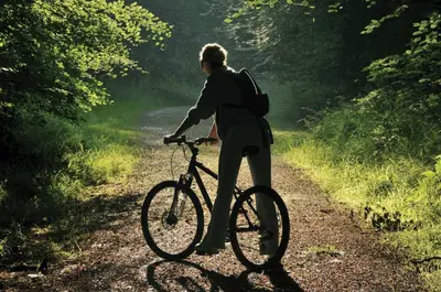 a person riding a bike on a dirt road at Prūsiškių dvaras in Sumiliszki