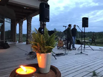 a group of people playing music on a deck with a candle at Prūsiškių dvaras in Sumiliszki