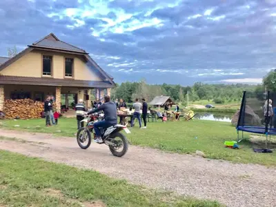 a man riding a motorcycle down a dirt road at Prūsiškių dvaras in Sumiliszki