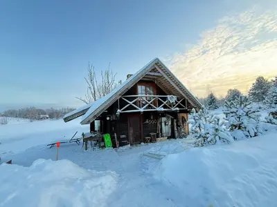 a log cabin in the snow with a mountain at Prūsiškių dvaras in Sumiliszki