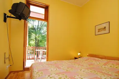 a yellow bedroom with a bed and a window at Parko Vila in Druskininkai