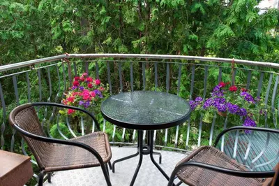 a table and chairs on a balcony with flowers at Petro delux apartments in Kaunas