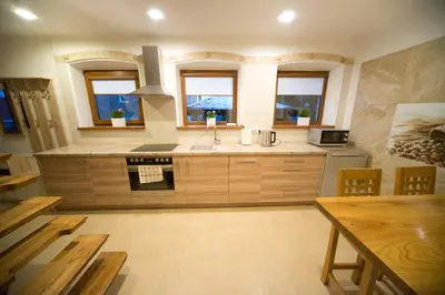 a large kitchen with a sink and a stove at Petro delux apartments in Kaunas