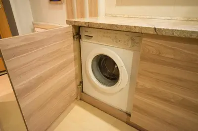 a washing machine in a kitchen with a counter at Petro delux apartments in Kaunas