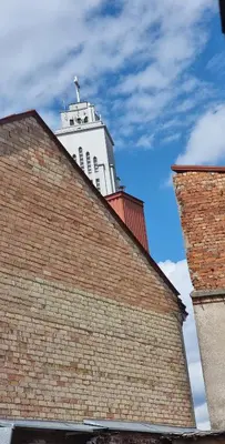 a white building behind a brick building at Petro delux apartments in Kaunas
