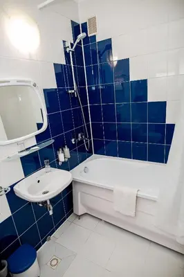 a blue and white bathroom with a tub and a sink at Hotel Tomas in Šiauliai
