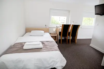 a bedroom with two beds and a table and chairs at Hotel Tomas in Šiauliai