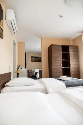 a hotel room with two beds and a television at Hotel Tomas in Šiauliai